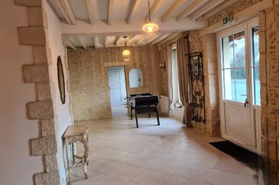 Douche avec carrelage sombre à gauche et meuble de salle de bain blanc avec vasque ronde à droite.