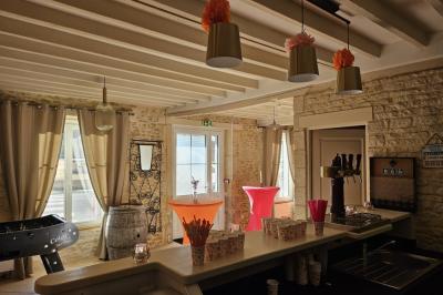 Douche avec carrelage sombre à gauche et meuble de salle de bain blanc avec vasque ronde à droite.