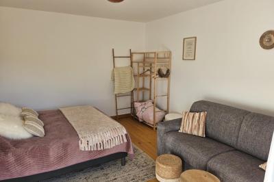 Douche à l'italienne avec carrelage sombre à gauche et lavabo blanc sur meuble en bois à droite.