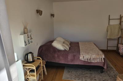 Douche à l'italienne avec carrelage sombre à gauche et lavabo blanc sur meuble en bois à droite.