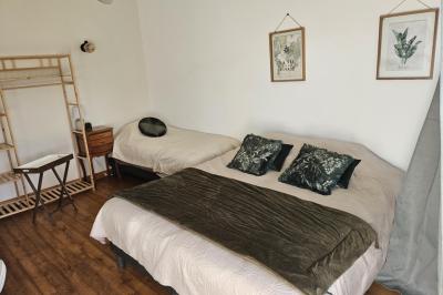 Douche à l'italienne avec carrelage sombre à gauche et lavabo blanc sur meuble en bois à droite.