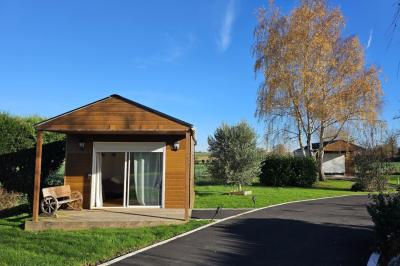 Douche à l'italienne avec carrelage sombre à gauche et lavabo blanc sur meuble en bois à droite.