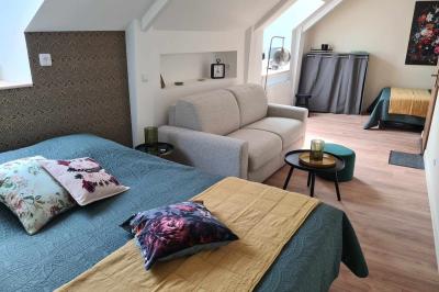 Douche à l'italienne avec carrelage sombre à gauche et lavabo blanc sur meuble en bois à droite.