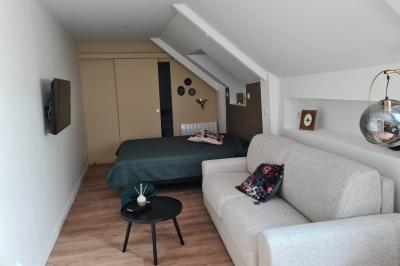 Douche à l'italienne avec carrelage sombre à gauche et lavabo blanc sur meuble en bois à droite.