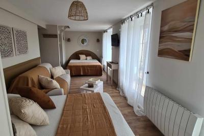 Douche à l'italienne avec carrelage sombre à gauche et lavabo blanc sur meuble en bois à droite.