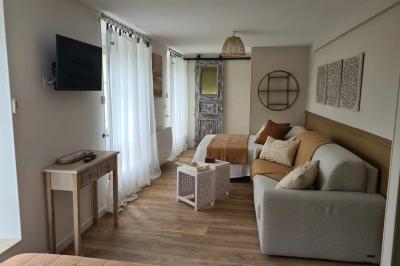 Douche à l'italienne avec carrelage sombre à gauche et lavabo blanc sur meuble en bois à droite.