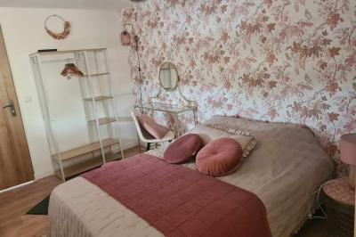 Douche à l'italienne avec carrelage sombre à gauche et lavabo blanc sur meuble en bois à droite.