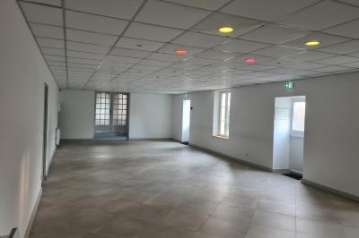 Douche à l'italienne avec carrelage sombre à gauche et lavabo blanc sur meuble en bois à droite.