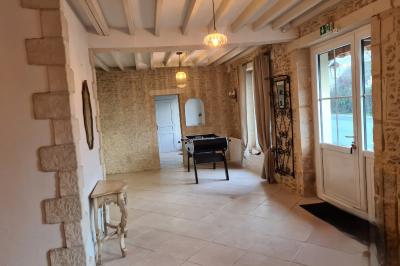 Douche à l'italienne avec carrelage sombre à gauche et lavabo blanc sur meuble en bois à droite.