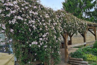 Douche à l'italienne avec carrelage sombre à gauche et lavabo blanc sur meuble en bois à droite.