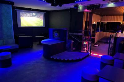 Vue d'une salle de bain avec un lavabo en vasque noire sur un plan en bois et un éclairage mural tamisé.