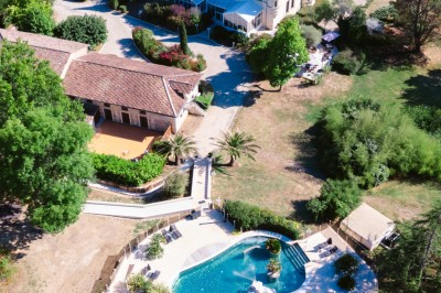 Table élégamment dressée en extérieur avec des fleurs pastel, des bougies et une grande bâtisse en arrière-plan.