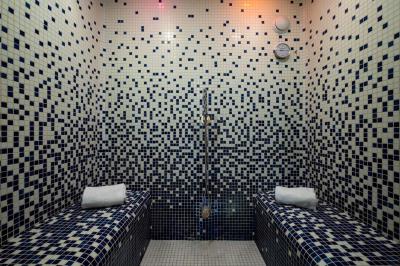 Chambre lumineuse avec lit double, bureau, télévision, machine à café et grande fenêtre offrant une vue extérieure.