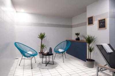 Chambre lumineuse avec lit double, bureau, télévision, machine à café et grande fenêtre offrant une vue extérieure.