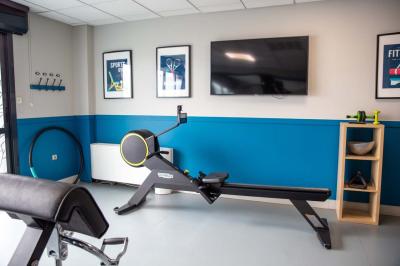 Chambre lumineuse avec lit double, bureau, télévision, machine à café et grande fenêtre offrant une vue extérieure.