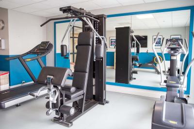 Chambre lumineuse avec lit double, bureau, télévision, machine à café et grande fenêtre offrant une vue extérieure.