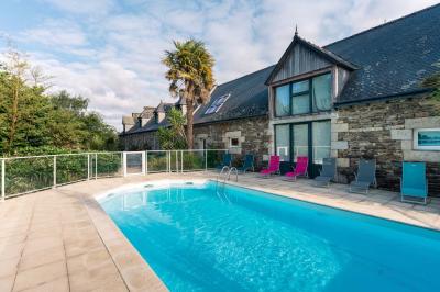 Chambre avec lit double, fauteuils colorés, escalier en colimaçon en bois et décoration chaleureuse.
