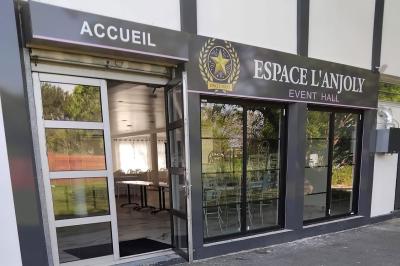 Panneau indiquant ’Espace L'Anjoly Event Hall’ avec des services comme location de salle, mariages et baptêmes.