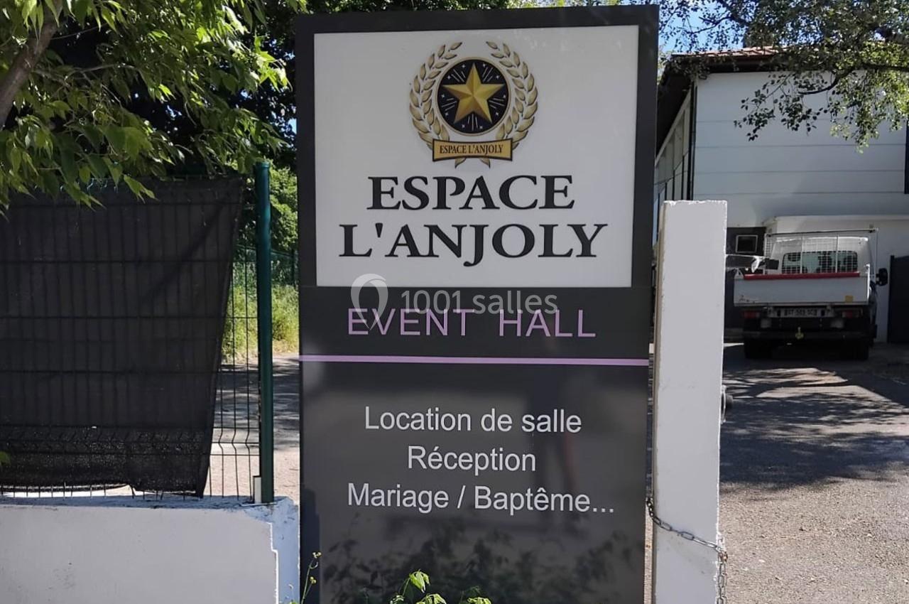Panneau indiquant ’Espace L'Anjoly Event Hall’ avec des services comme location de salle, mariages et baptêmes.