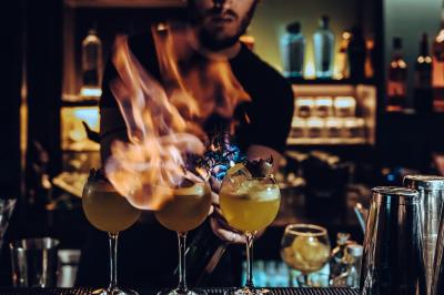 Main ajustant des commandes sur une table de mixage éclairée dans une ambiance sombre et lumineuse.