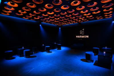 Main ajustant des commandes sur une table de mixage éclairée dans une ambiance sombre et lumineuse.