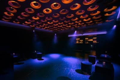 Main ajustant des commandes sur une table de mixage éclairée dans une ambiance sombre et lumineuse.