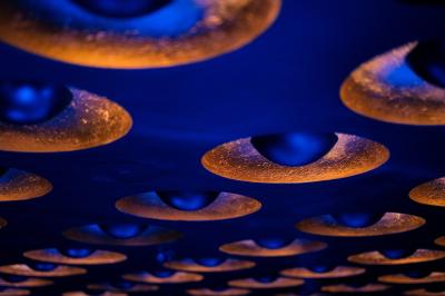 Main ajustant des commandes sur une table de mixage éclairée dans une ambiance sombre et lumineuse.