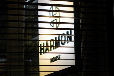 Main ajustant des commandes sur une table de mixage éclairée dans une ambiance sombre et lumineuse.