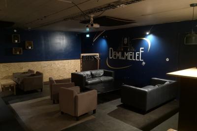 Deux micros sur scène dans une salle sombre, avec un écran lumineux affichant du texte en arrière-plan.