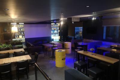 Deux micros sur scène dans une salle sombre, avec un écran lumineux affichant du texte en arrière-plan.