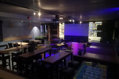 Deux micros sur pied dans une salle sombre, éclairée par un écran lumineux affichant un texte flou.