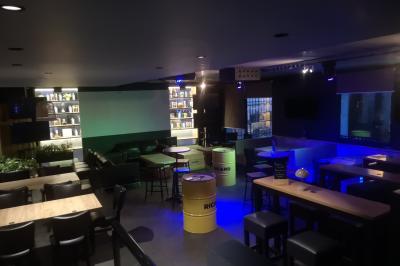 Deux micros sur pied dans une salle sombre, éclairée par un écran lumineux affichant un texte flou.