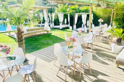 Chambre lumineuse avec jacuzzi intégré, lit double, murs en pierre blanche et décoration élégante.