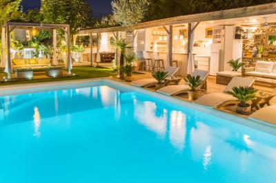 Chambre lumineuse avec jacuzzi intégré, lit double, murs en pierre blanche et décoration élégante.