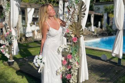 Chambre lumineuse avec jacuzzi intégré, lit double, murs en pierre blanche et décoration élégante.