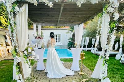 Chambre lumineuse avec jacuzzi intégré, lit double, murs en pierre blanche et décoration élégante.