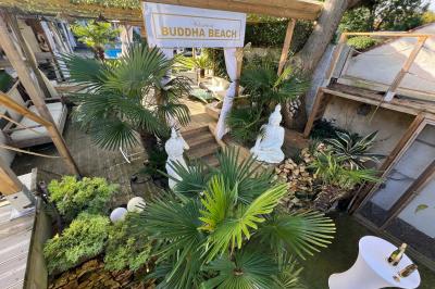 Chambre lumineuse avec jacuzzi intégré, lit double, murs en pierre blanche et décoration élégante.