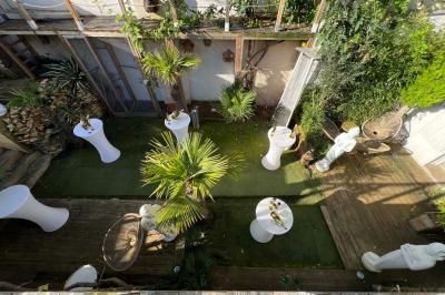 Chambre lumineuse avec jacuzzi intégré, lit double, murs en pierre blanche et décoration élégante.