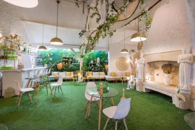 Chambre lumineuse avec jacuzzi intégré, lit double, murs en pierre blanche et décoration élégante.