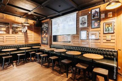 Salle de bar avec des murs en bois, des tables et chaises alignées, et une grande inscription ’French Flair’ sur le mur.
