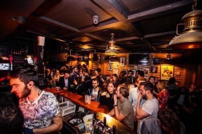 Salle intérieure d’un bar avec des murs décorés du texte ’French Flair’, des tables et des chaises en bois.