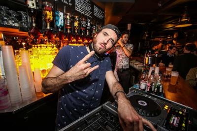 Salle intérieure d’un bar avec des murs décorés du texte ’French Flair’, des tables et des chaises en bois.