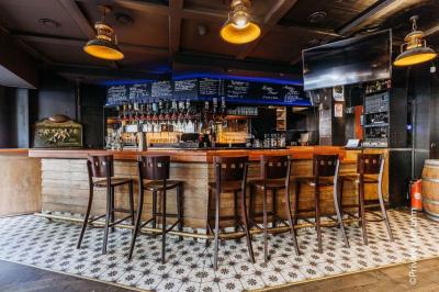 Salle intérieure d’un bar avec des murs décorés du texte ’French Flair’, des tables et des chaises en bois.