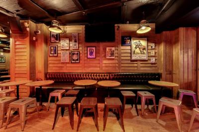 Salle intérieure d’un bar avec des murs décorés du texte ’French Flair’, des tables et des chaises en bois.