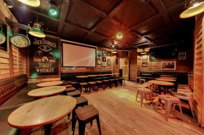 Salle intérieure d’un bar avec des murs décorés du texte ’French Flair’, des tables et des chaises en bois.