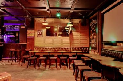 Salle intérieure d’un bar avec des murs décorés du texte ’French Flair’, des tables et des chaises en bois.