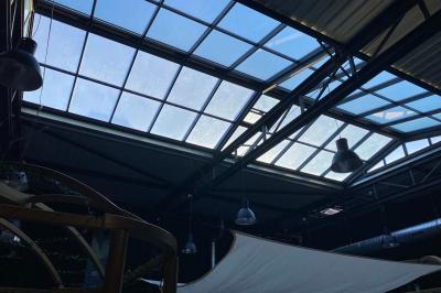 Groupe de personnes rassemblées dans un bar animé, regardant un match de sport diffusé sur des écrans géants.