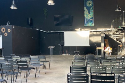 Groupe de personnes rassemblées dans un bar animé, regardant un match de sport diffusé sur des écrans géants.