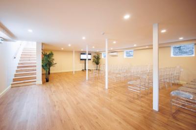 Bateau naviguant sur une rivière avec des passagers debout sur le pont supérieur près d'un quai en pierre.