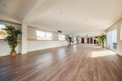 Bateau naviguant sur une rivière avec des passagers debout sur le pont supérieur près d'un quai en pierre.